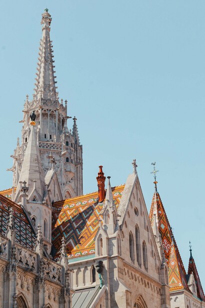 The colourful tiled roof and towering spire of Matthias Church in Budapest, Hungary, symbolising the value of integrity, stewardship, and genuine worship