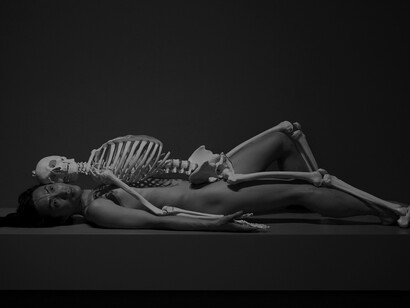 Jonathan Muzikar's photograph capturing Marina Abramović's artwork: a naked person lying under a skeleton