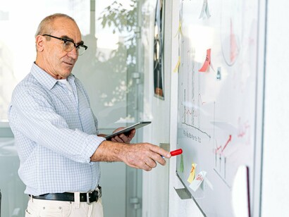A professional reviewing performance charts on a whiteboard, representing the importance of measuring what truly matters