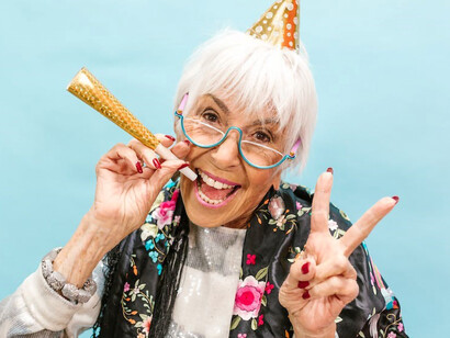 On the occasion of her birthday, an elderly lady beams with pure joy, embracing life's blessings and relishing the celebration to the fullest