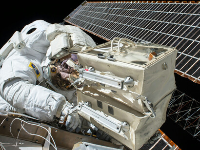 A NASA astronaut performs maintenance on a satellite in space