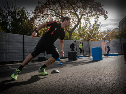 A man is running a course at an outdoor exercise facility in Paris, France