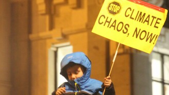 Niño sosteniendo un cartel que dice "Detén el caos climático ahora" durante la Marcha por el Clima, Madrid, España, 6 de diciembre de 2019