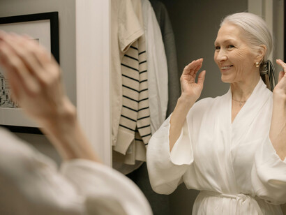 An aging woman getting ready in the bathroom, calm, confident, and happy