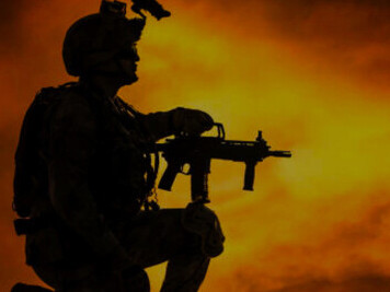 The silhouette of a soldier set against an abstract orange background