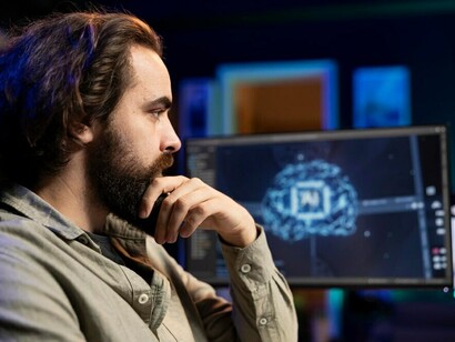 A man using a desktop PC to work on AI deep neural networks, focusing on advancements like generative AI, AI chatbots, and machine learning