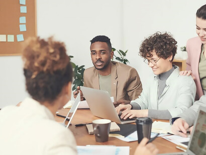 Amidst a collaborative scene, business professionals discuss documents, showcasing the vital role of communication in fostering shared understanding and informed decision-making