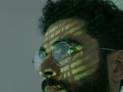 A man engaged with the AI while a binary code swallows his forehead and face