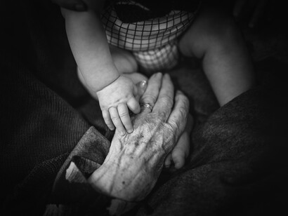 Abuelo y bebé se cogen de las manos