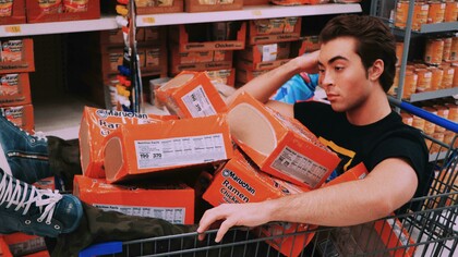 Depressed-looking man slumped on a shopping cart, symbolizing the emotional toll of unhealthy lifestyle habits