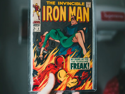 A person holds an Iron Man comic book, showcasing Marvel's legendary graphic design and cultural significance