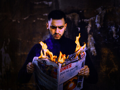 A man reads a newspaper on fire