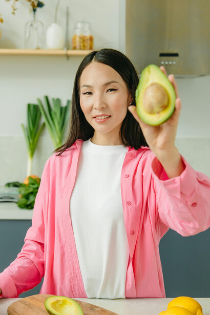 A woman presenting a avocado, reflecting the essence of healthy eating and the simplicity of a plant-based vegan diet