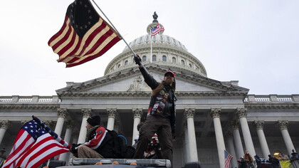 Hombre hondea una bandera de Estados Unidos en el Asalto al Capitolio el 6 de enero de 2021 en Washington D.C.
