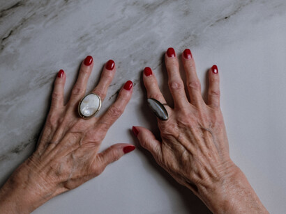 An older woman's hands flat on the surface can show her aging