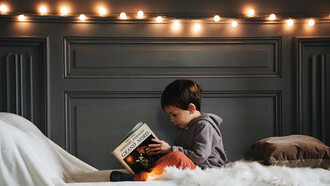 Pequeño niño observando atentamente un libro antes de acostarse