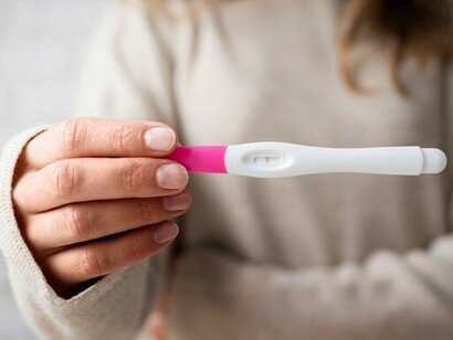 A woman's hand reveals a positive pregnancy test result, highlighting a life-changing moment