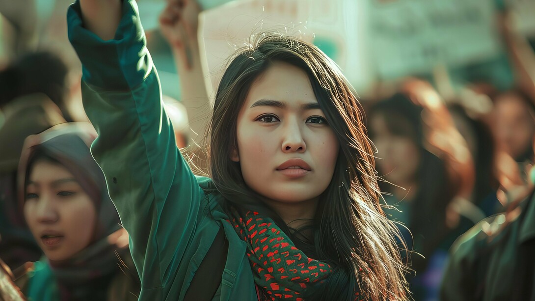 A young woman raising her hand in a call for change, representing how youth guide discussions where traditional politics often chooses to remain silent