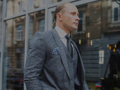 A businessman in a suit standing in front of a glass window, embodying professionalism and corporate success