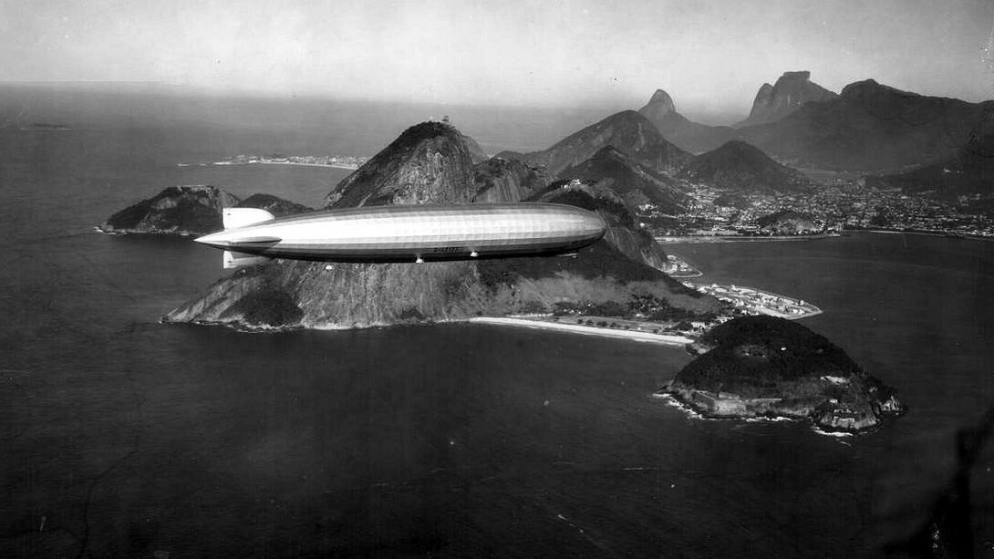 Dirigível LZ 127 "Graf Zeppelin" sobre o Rio de Janeiro. Estávamos todos juntos, minha mãe, meu pai, meus irmãos. Meus pais tinham me dado a permissão rara de andar um pouco mais longe, mas eu sabia que não podia ir muito além da barraca da pipoca. Ainda assim, minha curiosidade me empurrava, como sempre fazia