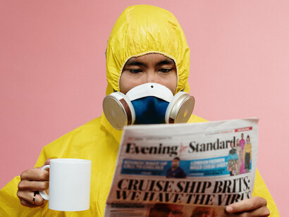 Profissional da saúde lê notícias do dia usando máscara de proteção