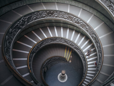 The spiral staircase of the Vatican Museums in Vatican City, representing how continuous architectural flow naturally guides movement