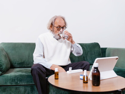 An elderly man carefully organizes his daily regimen of essential supplements to support his overall health and well-being