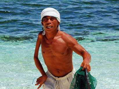 A fisherman on Mindanao's pristine beaches reflects the region's untouched natural charm, a perfect balance between environmental conservation and tourism growth