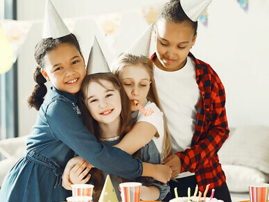 In the midst of her birthday festivities, the child revels in pure joy, surrounded by friends, creating a scene filled with celebration and laughter