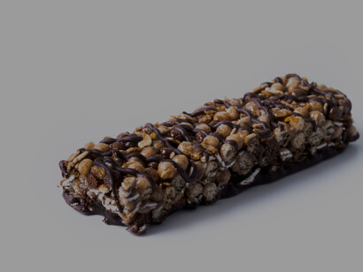 High-protein muesli bars made with nuts and seeds, photographed in close-up on a table and isolated on a white background with visible ingredients