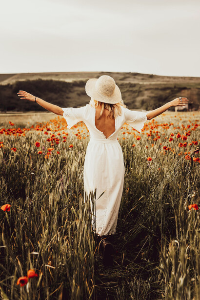 Joven en un campo de flores. Recargar las energías también implica dedicar tiempo a actividades que dan felicidad