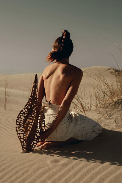 Part of the wind-swept landscape, Karlien faces the horizon beside ‘Diatom Bokeh’ from the Epiphanic series collaboration with Reticence Studio, photographed by Driaan Claassen