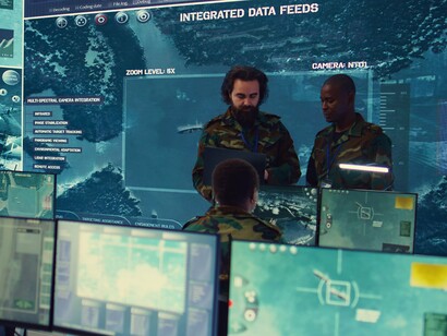 Analistas monitoram dados em centro de inteligência cercado por sistemas digitais. O avanço das tecnologias de vigilância amplia o debate sobre poder, controle social e autoritarismo