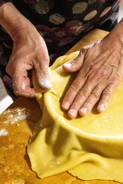 A homemade pie begins with dough carefully shaped on a wooden board