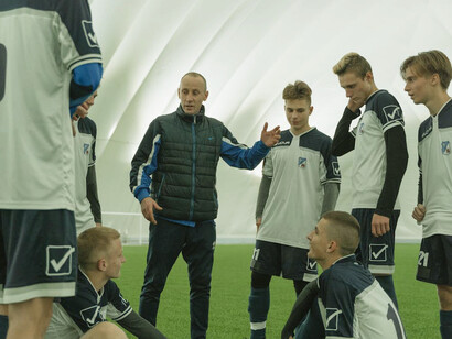 Focused and engaged, the soccer team listens intently, demonstrating how effective leadership can enhance team cohesion and performance