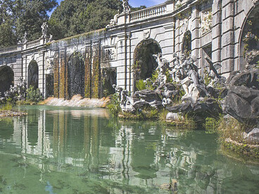 The Caserta monumental complex, designed by Luigi Vanvitelli in the late eighteenth century for Charles of Bourbon, was intended to rival Versailles and Madrid. It includes the Royal Palace, its gardens and park, a wooded area, the Carolino Aqueduct, and the San Leucio silk–producing industrial site