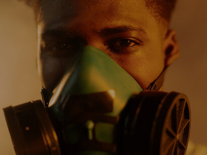 Amid the climate crisis and its unfolding changes, a man in a gas mask grapples for each breath, a poignant image of our environmental challenges