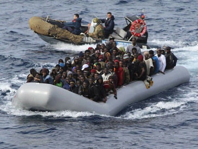 Los guardacostas, rodeando una lancha neumática llena de inmigrantes
