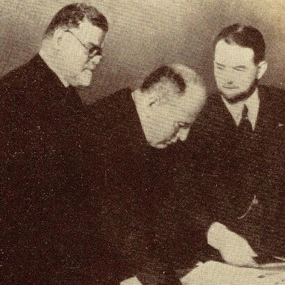 Benito Mussolini, e Giovanni Gentile alle spalle, mentre esamina i primi volumi dell'Enciclopedia Italiana