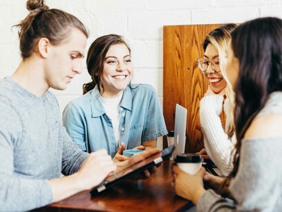 Colleagues in a relaxed social situation going over the latest team project as they assume their roles in the teamwork sphere