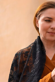 A woman prays with a crucifix in her hands before the cathedral