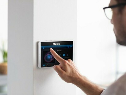Person using a smartphone in an automated, AI-designed smart home interior