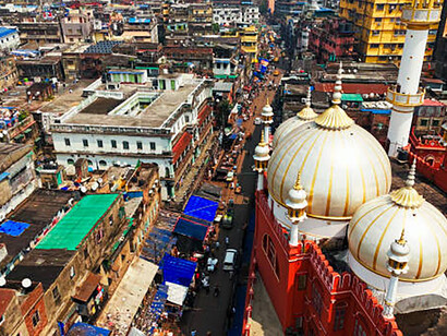 Aerial view of a mosque nestled among the urban buildings of Kolkata, India, highlighting the contrast between religious architecture and modern city structures