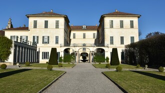 Villa Panza vista dal giardino principale. La villa oggi ha mantenuto il suo impianto originale a U, aperto verso ovest e sviluppato su tre piani, caratterizzato da un porticato a tre archi che circonda il cortile lungo il lato aperto della U