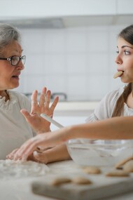 A grandmother and a granddaughter making cookies together 