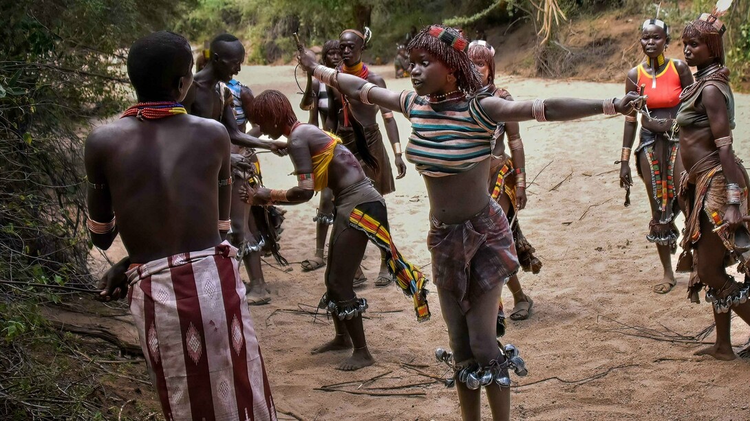 Mulheres são chicoteadas em ritual tradicional da tribo Hamar. Não se trata de crueldade ou sofrimento, mas como um símbolo de força e resistência. O objetivo é mostrar que estão ali para encorajar o rapaz que está prestes a saltar sobre as vacas, um dos maiores testes de bravura da tribo. O salto, que deve ser feito sem hesitação, simboliza a passagem do menino para a fase adulta e a preparação para o casamento. Se ele conseguir saltar todas as vacas de uma vez, se tornará um homem e estará pronto para se casar. Caso não consiga, poderá tentar novamente, mas o fracasso inicial traz grande vergonha para a família