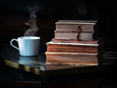 Tasa de té caliente junto a una pila de libros