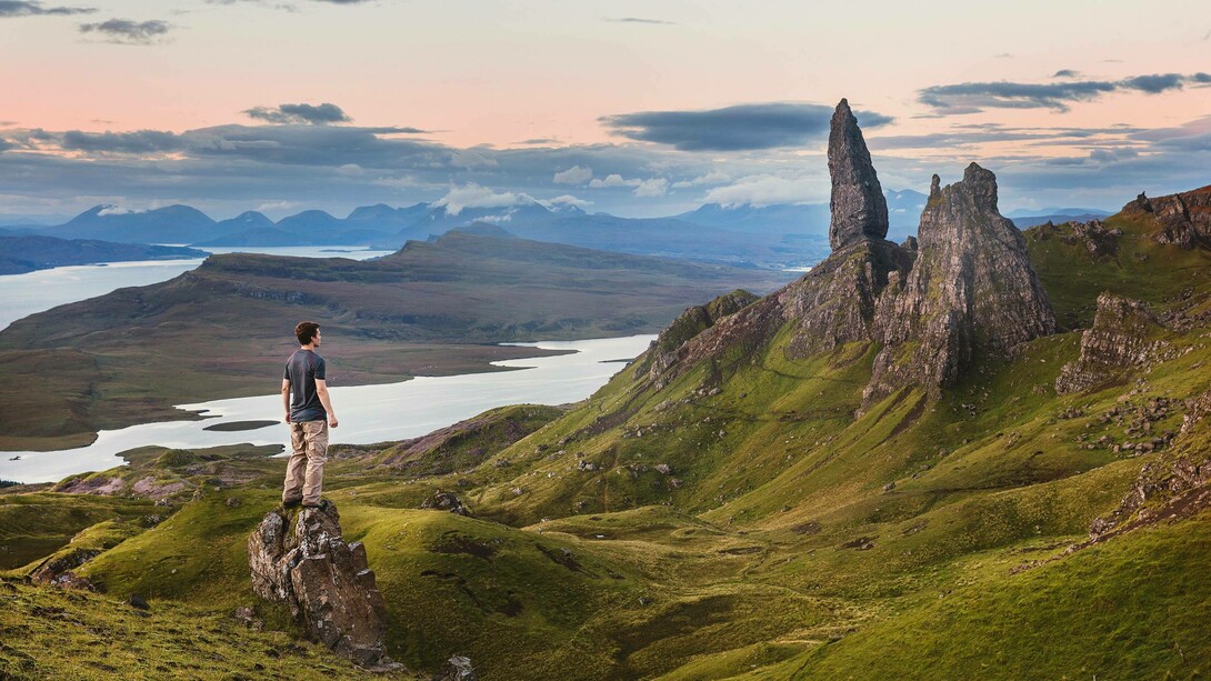 A man standing in a mountainous region wondering how to create a better world