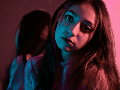 A woman looking at the camera with quiet intensity, symbolising the courage to face herself honestly