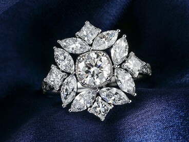 Diamond ring arranged on a blue velvet surface, representing the global demand for luxury built on extractive economies